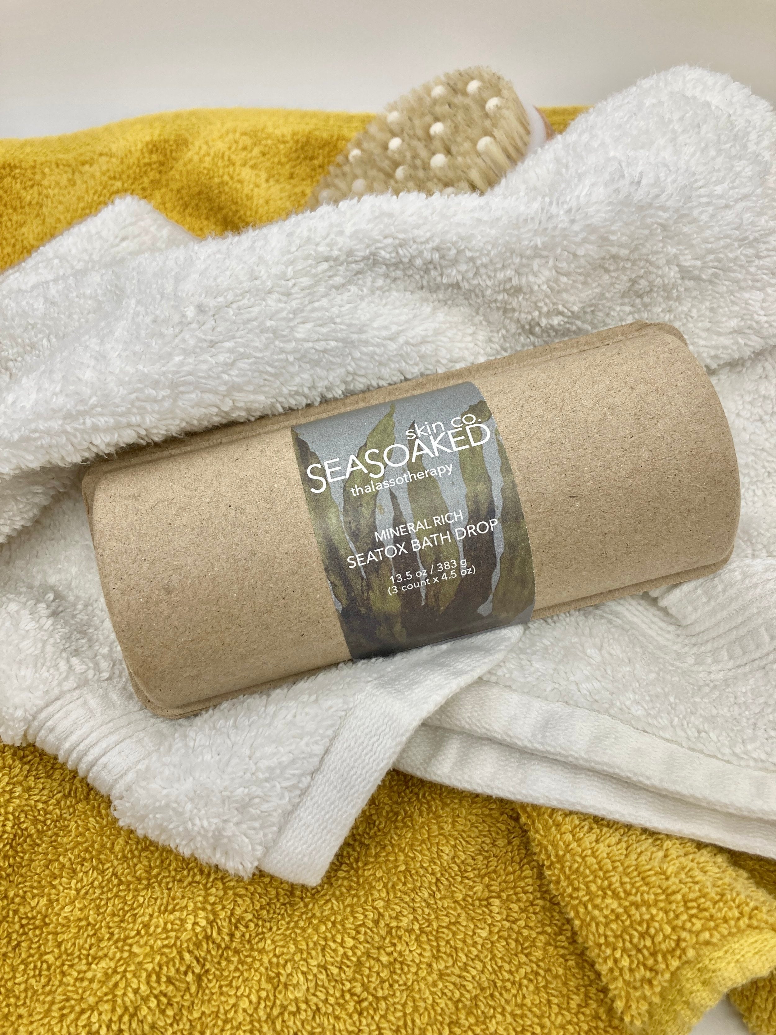 Seatox Bath Drop package on white and yellow towels.