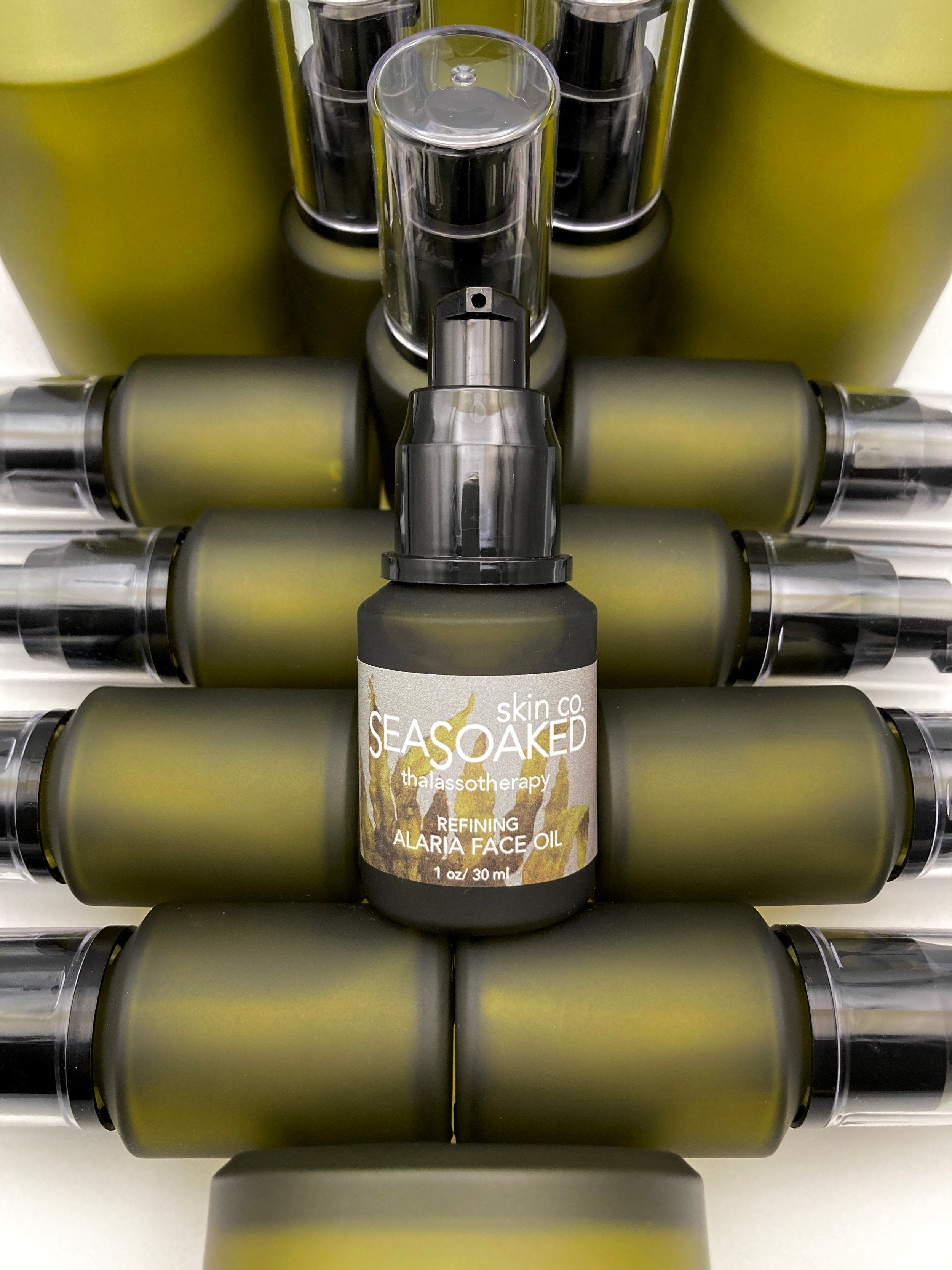 Artistic arrangement of Alaria Face Oil bottles.